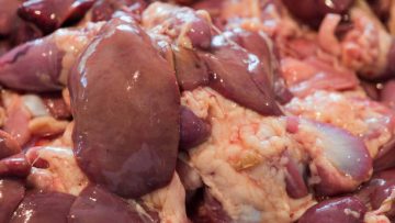 Fresh chicken entrails on display in a meat market counter